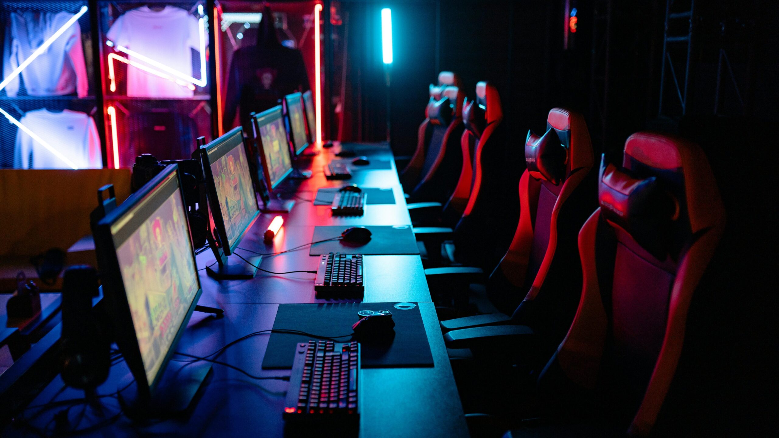 High-tech gaming setup with PCs, RGB lighting, and gaming chairs in a gaming house.